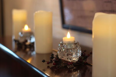 Close-up of lit candles on table at home