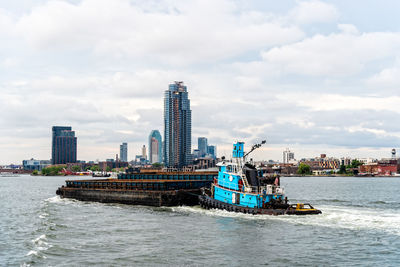 Tugboat pusing barge on east river, nyc