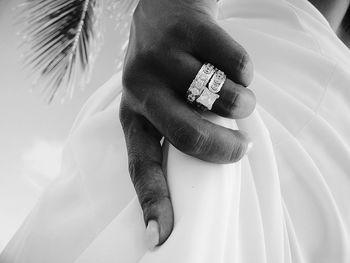 Cropped hand of bride holding dress 