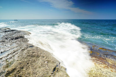 View of calm beach against blue sky