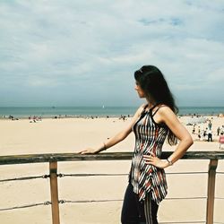 Woman standing on beach against sky