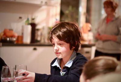 Boy holding drinking glass in kitchen