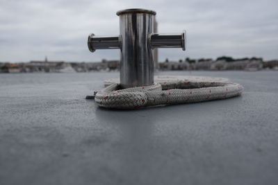 Close-up of pole with rope against sky