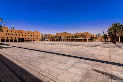 Historical building in city against clear blue sky