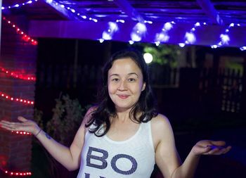 Portrait of smiling woman standing at night