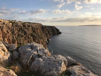 Rock formations on sea shore against sky