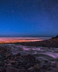 Scenic view of sea against clear sky at night