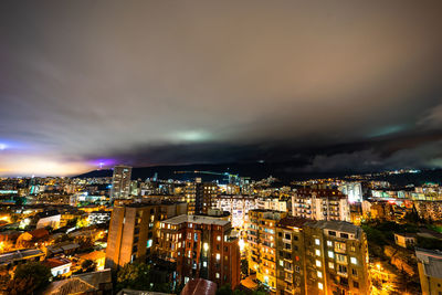 High angle view of illuminated cityscape against sky at night