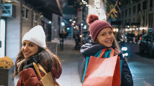 Portrait of smiling young woman in city during winter