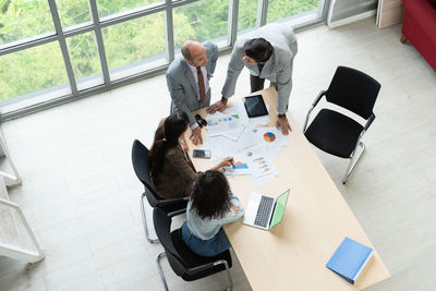 High angle view of business colleagues discussing at office