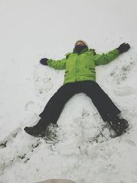 Full length of boy making snow angel on field