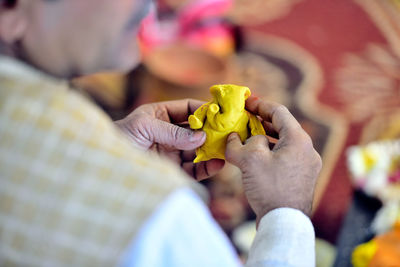 Close-up of hand holding yellow leaf