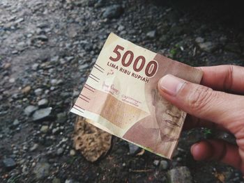 High angle view of hand holding paper with text