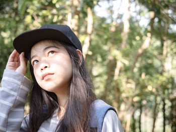Young woman wearing cap looking away