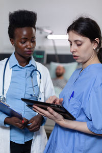 Doctor and nurse looking at reports in digital tablet