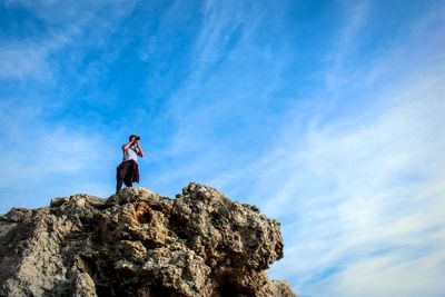 Low angle view of men standing against sky