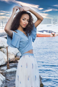 Portrait of beautiful young woman standing at beach