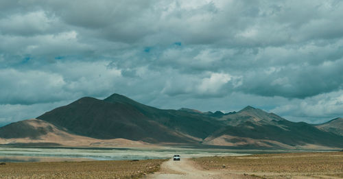 Scenic view of land and mountains against sky