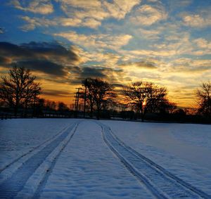Scenic view of snow covered landscape at sunset