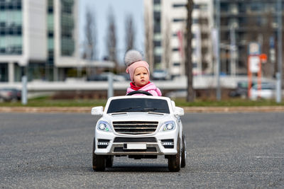 Little girldriving a toy car. little driver, childrens car, concept of road safety, children in car