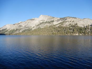 Scenic view of sea and mountains against clear blue sky