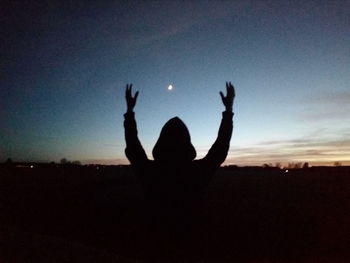 Silhouette of friends against sky at sunset