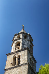 Low angle view of bell tower against blue sky