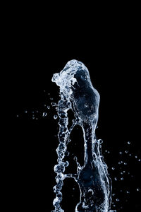 Close-up of water splashing against black background