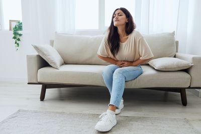 Young woman sitting on sofa at home