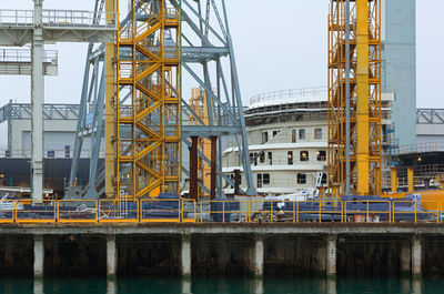 Cranes at construction site against sky