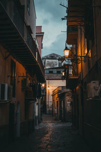 Alley amidst buildings in city at night