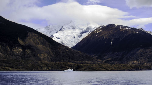 Scenic view of mountains and sea against cloudy sky