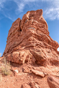 Low angle view of rock formations in desert with blue sky