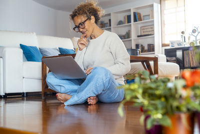 Young woman using laptop while sitting at home