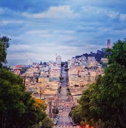 Buildings in city against cloudy sky