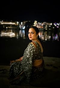 Portrait of young woman looking away at night