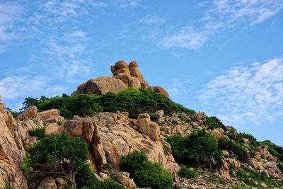 Low angle view of rock against cloudy sky