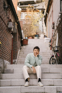 Portrait of young man sitting on staircase