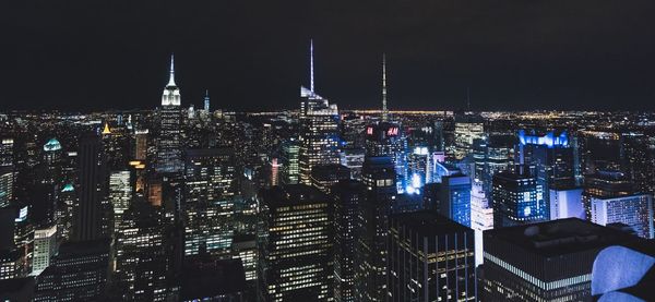 Illuminated cityscape against sky at night