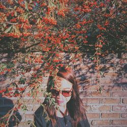 Young woman standing by wall