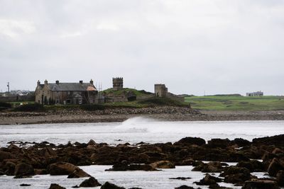 Houses by sea against sky