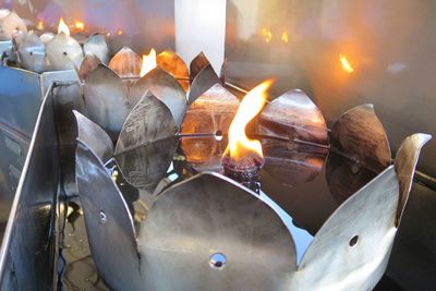 Close-up of burning candles on metal