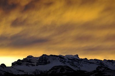 Scenic view of snowcapped mountains against sky during sunset