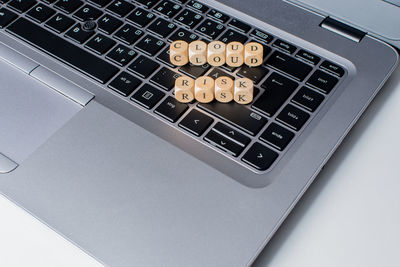 High angle view of alphabets in wooden blocks on laptop keyboard