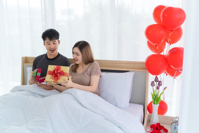 Young couple sitting on wall