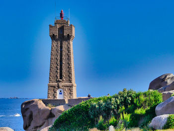 Low angle view of lighthouse against clear blue sky