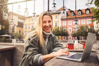 Portrait of young woman using laptop at home