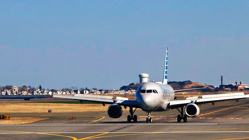 Airplane on runway against sky