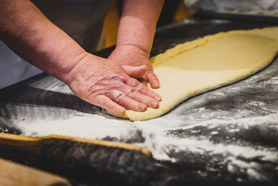 Midsection of man preparing cookies with dough at counter