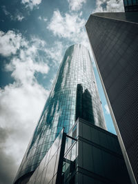 Low angle view of modern glass building against sky